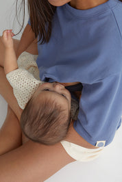 Maman qui allaite bébé dans ses bras et qui porte le tee-shirt box d'allaitement couleur bleu de mèr(e)