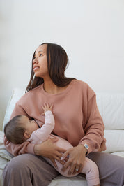 Maman qui allaite bébé assise, porte le crewneck d'allaitement couleur Câlin