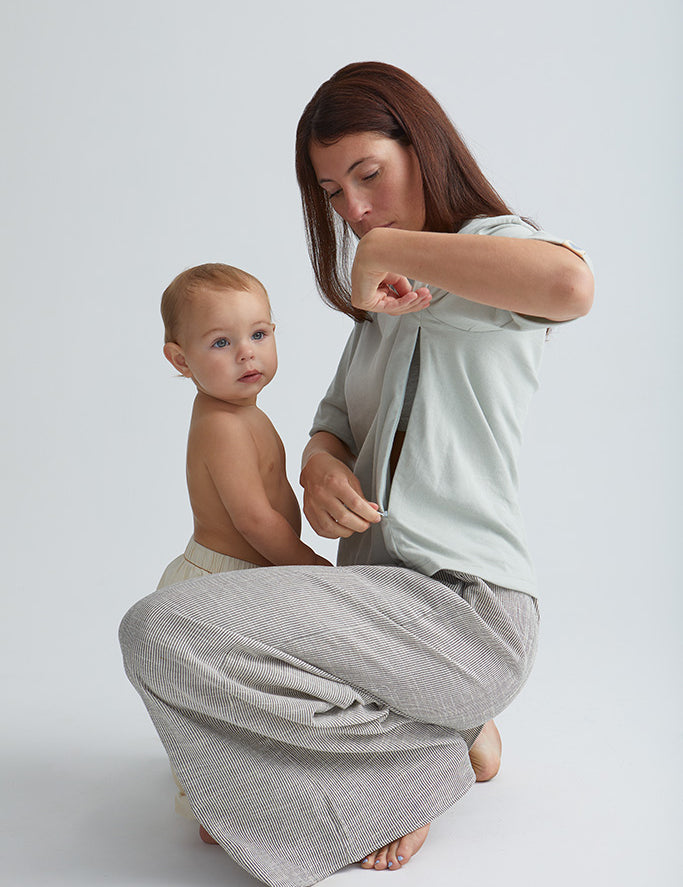 Maman devant son bébé qui ouvre le zip de son teeshirt box d'allaitement couleur seaglass.