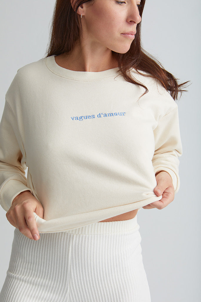 Maman debout et qui porte le crewneck d'allaitement Vagues d'amour couleur nacre avec broderie bleue