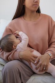 Maman qui allaite bébé assise, porte le crewneck d'allaitement couleur Câlin