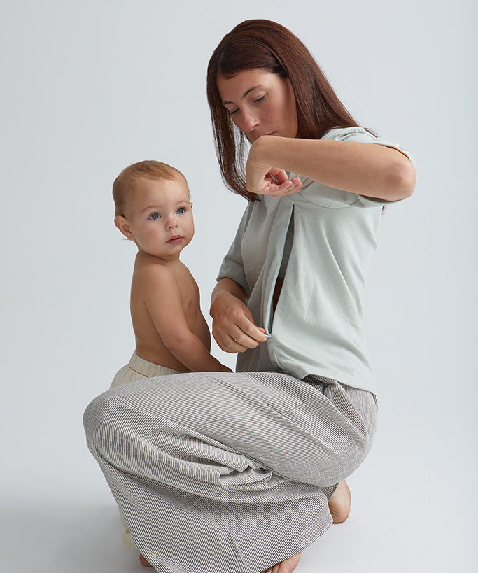 Maman devant son bébé qui ouvre le zip de son teeshirt box d'allaitement couleur seaglass.