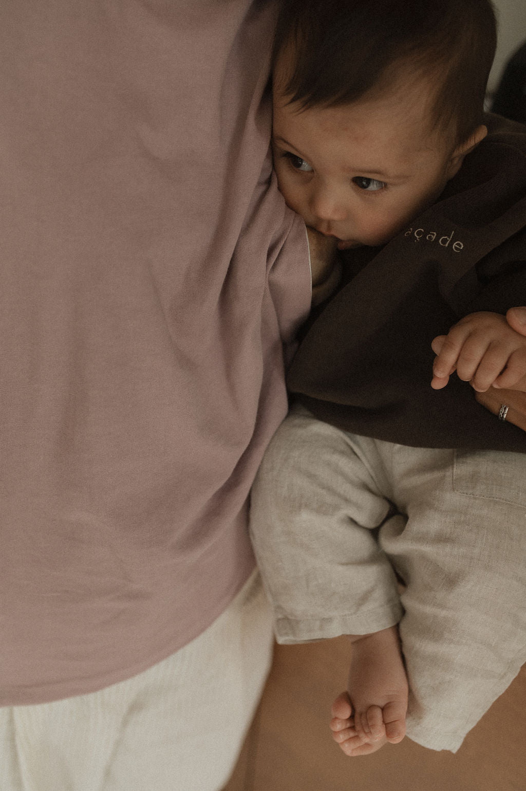 Maman dans la cuisine, avec bébé sur le comptoir, qui va allaiter bébé avec teeshirt d'allaitement Marées couleur Aube