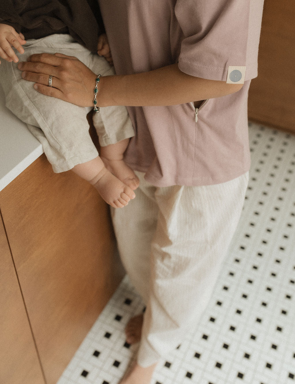 Maman dans la cuisine, avec bébé sur le comptoir, qui va allaiter bébé avec teeshirt d'allaitement Marées couleur Aube