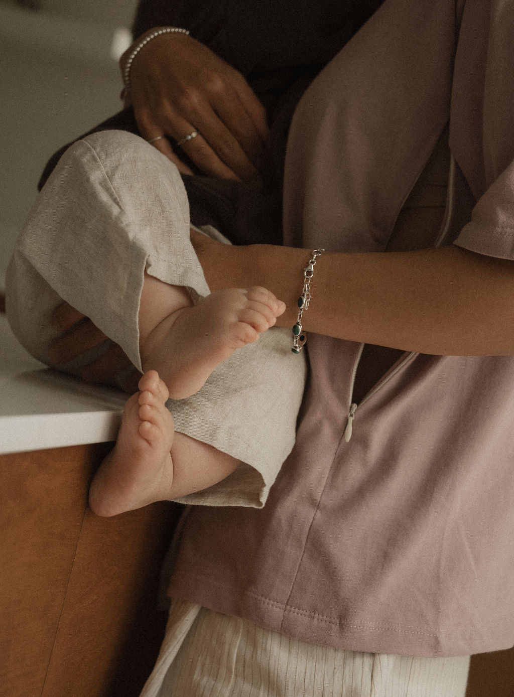 Maman dans la cuisine, avec bébé sur le comptoir, qui va allaiter bébé avec teeshirt d'allaitement Marées couleur Aube