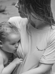 Maman en train d'allaiter sa fille, près d'une cascade dans un tee-shirt d'allaitement vague d'amour avec ouvertures latérales. Cheveux mouillés après une baignade.