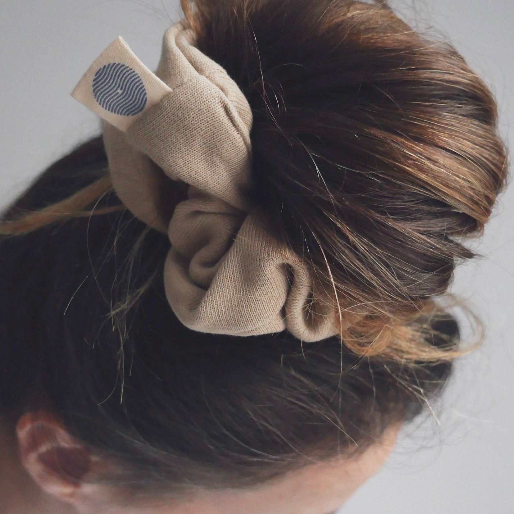 Close up sur chignon fait avec chouchou couleur sable doux.